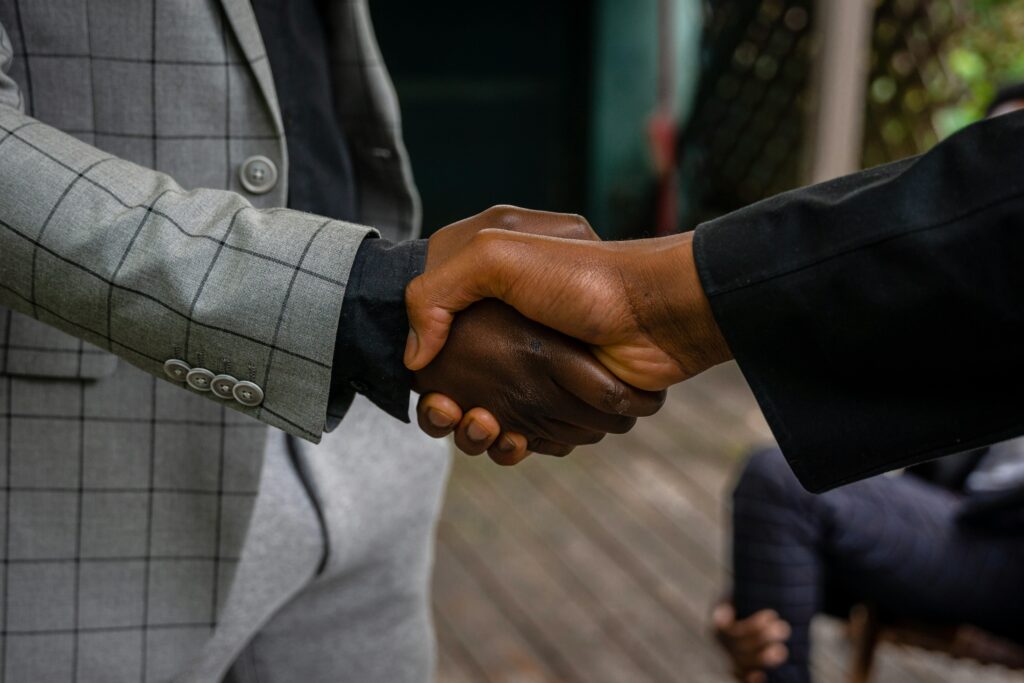 Usługi Close-up of two professionals shaking hands, symbolizing success and partnership.